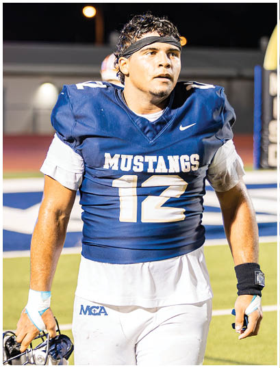 A football player wearing a blue and white uniform. Description generated by AI