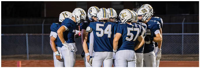 A group of football players on a field. Description generated by AI
