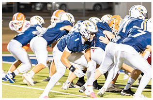 A group of football players on a field. Description generated by AI