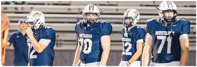 A group of football players on a field. Description generated by AI