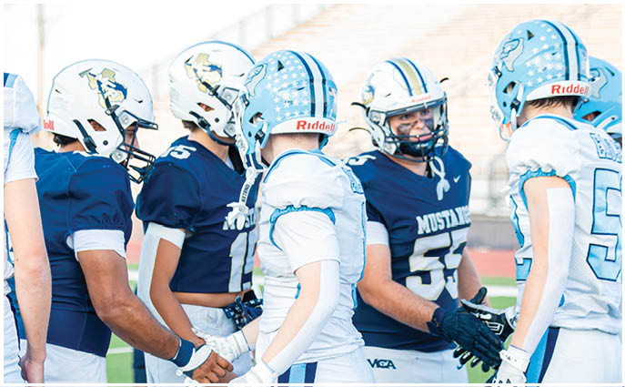 A group of football players on a field. Description generated by AI
