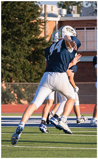 A football player catching a ball. Description generated by AI