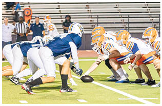 A group of football players on a field. Description generated by AI
