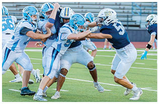 A group of football players on a field. Description generated by AI