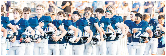 A group of football players on a field. Description generated by AI