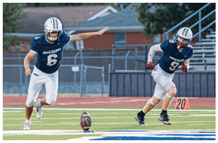 A group of football players on a field. Description generated by AI