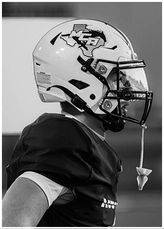A group of football players wearing black and white uniforms. Description generated by AI