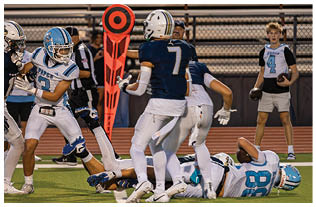 A group of football players on a field. Description generated by AI