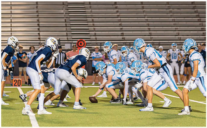 A group of football players on a field. Description generated by AI