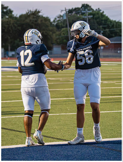 A football player wearing a blue and white uniform. Description generated by AI