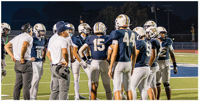 A group of football players on a field. Description generated by AI