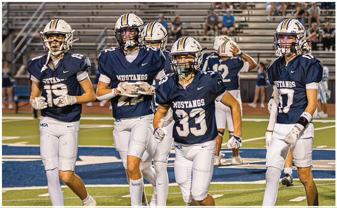 A group of football players on a field. Description generated by AI