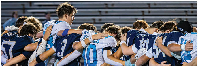A group of football players on a field. Description generated by AI