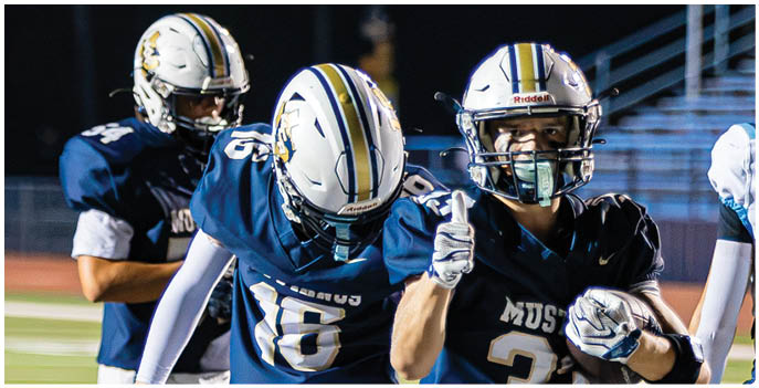 A group of football players on a field. Description generated by AI