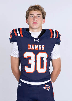 A young man wearing a white and black jersey with the number 14 on it. Description generated by AI