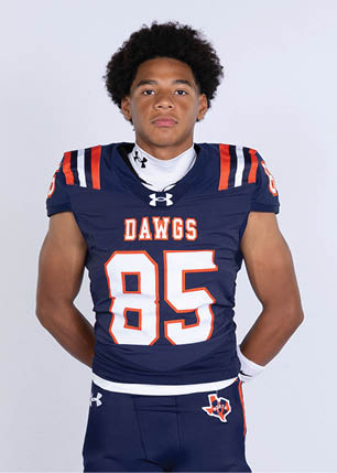 A young man wearing a white and black jersey with the number 14 on it. Description generated by AI