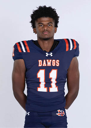 A young man wearing a white and black jersey with the number 14 on it. Description generated by AI