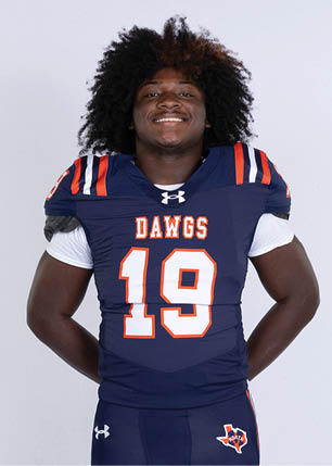 A young man wearing a white and black jersey with the number 14 on it. Description generated by AI