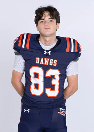 A young man wearing a white and black jersey with the number 14 on it. Description generated by AI