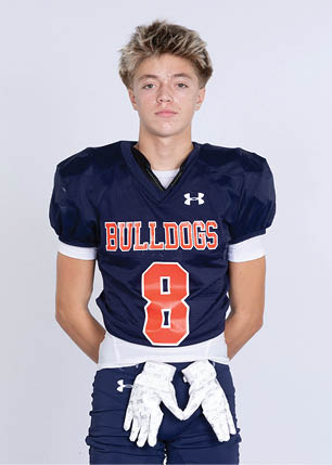 A young man wearing a white and black jersey with the number 14 on it. Description generated by AI