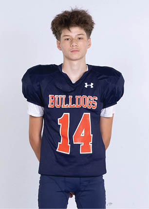 A young man wearing a white and black jersey with the number 14 on it. Description generated by AI
