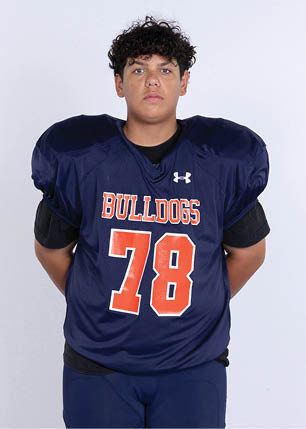 A young man wearing a white and black jersey with the number 14 on it. Description generated by AI