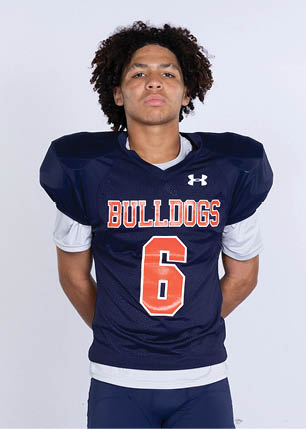 A young man wearing a white and black jersey with the number 14 on it. Description generated by AI
