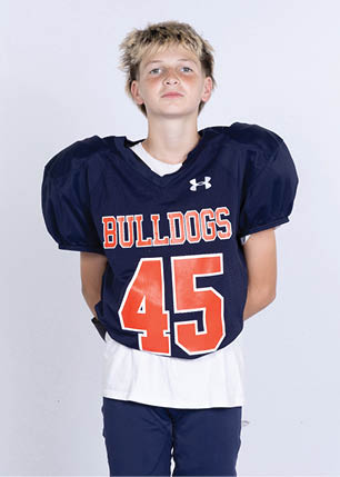 A young man wearing a white and black jersey with the number 14 on it. Description generated by AI