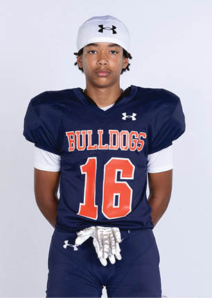 A young man wearing a white and black jersey with the number 14 on it. Description generated by AI