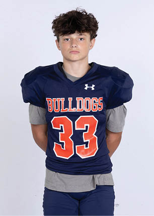 A young man wearing a white and black jersey with the number 14 on it. Description generated by AI