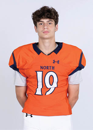 A young man wearing a white and black jersey with the number 14 on it. Description generated by AI