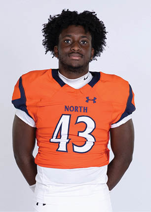 A young man wearing a white and black jersey with the number 14 on it. Description generated by AI