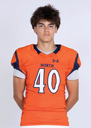 A young man wearing a white and black jersey with the number 14 on it. Description generated by AI