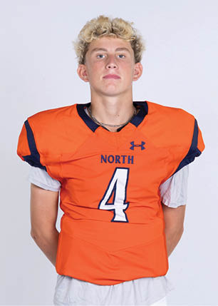 A young man wearing a white and black jersey with the number 14 on it. Description generated by AI