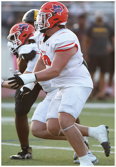 A football player wearing a blue and white uniform. Description generated by AI