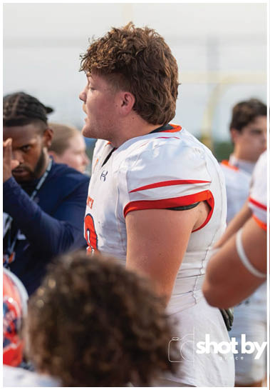 A football player wearing a blue and white uniform. Description generated by AI