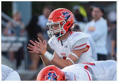 A football player wearing a blue and white uniform. Description generated by AI
