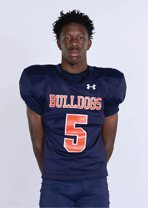 A young man wearing a white and black jersey with the number 14 on it. Description generated by AI