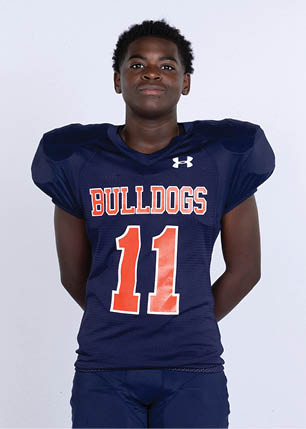 A young man wearing a white and black jersey with the number 14 on it. Description generated by AI