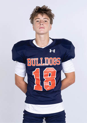 A young man wearing a white and black jersey with the number 14 on it. Description generated by AI