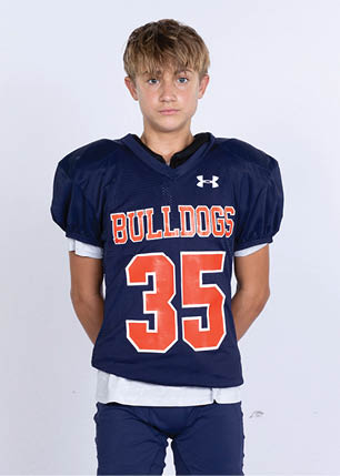 A young man wearing a white and black jersey with the number 14 on it. Description generated by AI
