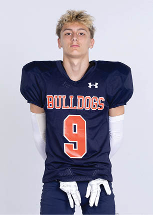 A young man wearing a white and black jersey with the number 14 on it. Description generated by AI