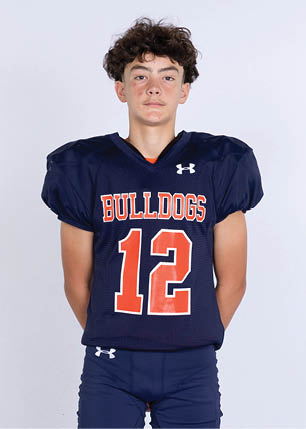 A young man wearing a white and black jersey with the number 14 on it. Description generated by AI