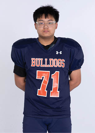 A young man wearing a white and black jersey with the number 14 on it. Description generated by AI
