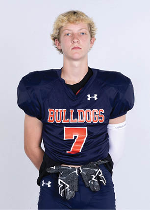 A young man wearing a white and black jersey with the number 14 on it. Description generated by AI