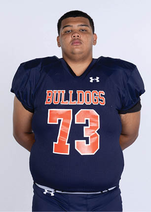 A young man wearing a white and black jersey with the number 14 on it. Description generated by AI