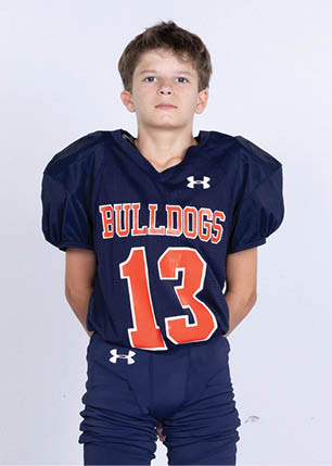 A young man wearing a white and black jersey with the number 14 on it. Description generated by AI