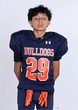 A young man wearing a white and black jersey with the number 14 on it. Description generated by AI