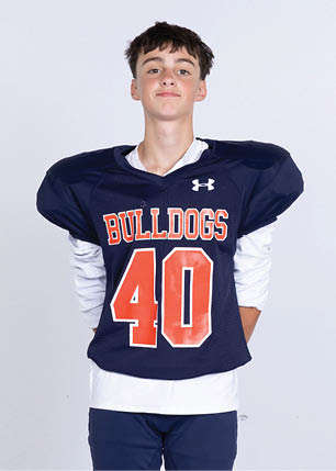 A young man wearing a white and black jersey with the number 14 on it. Description generated by AI