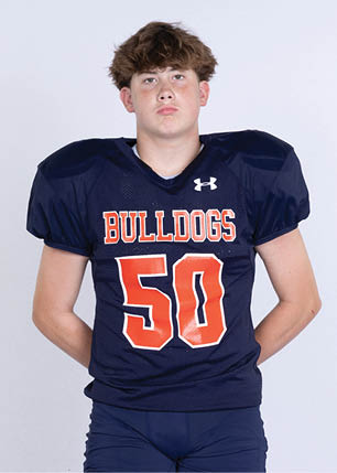 A young man wearing a white and black jersey with the number 14 on it. Description generated by AI